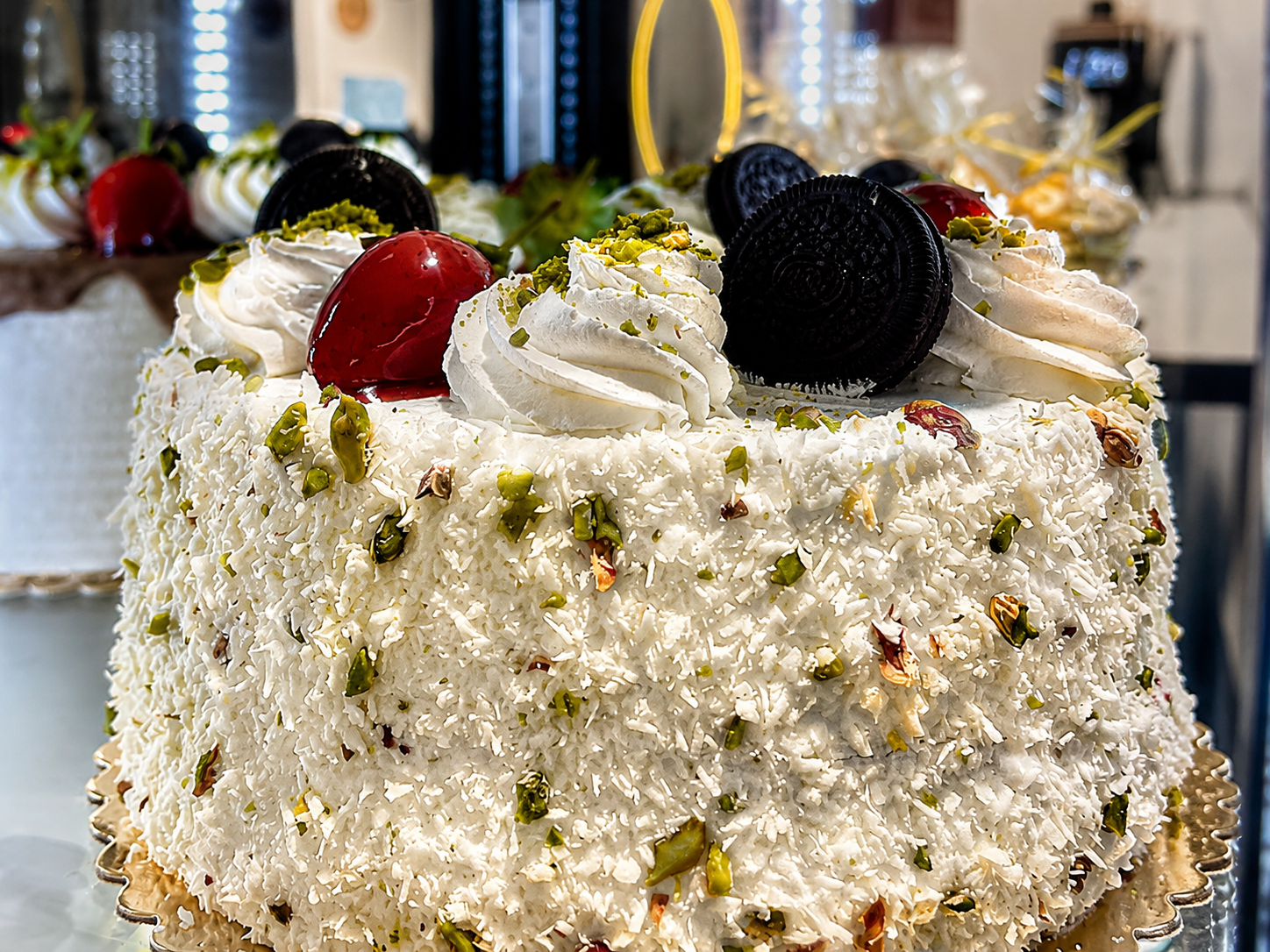 KI-verbesserte weiße Torte mit Kokosraspeln und Pistazien