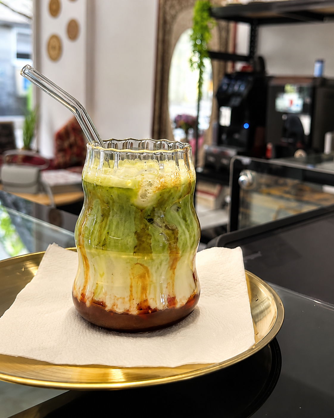 KI-verbesserter Iced Matcha im Glas auf einem Tablett