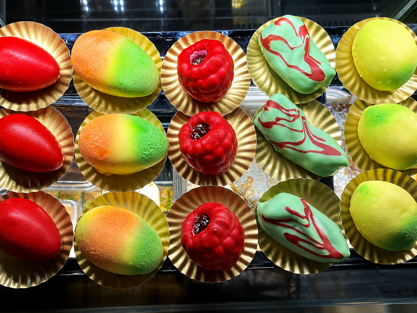 KI-verbesserte bunte kleine Patisserie und Desserts in einer Vitrine